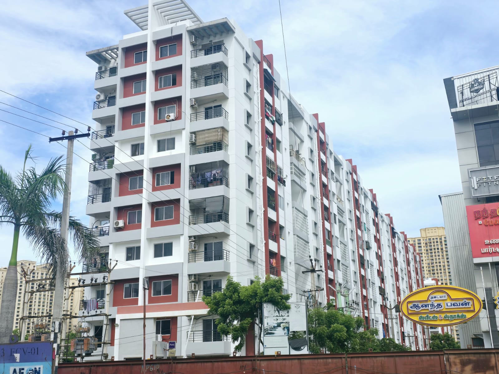 Painter rolling paint on wall — Full Building Repaint Adyar